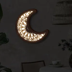 Vista dettagliata della lampada da parete LED luna in legno boho, con luce calda soffusa.