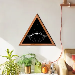 Close-up detail of triangular wooden wall art featuring celestial moon phases and boho hands.