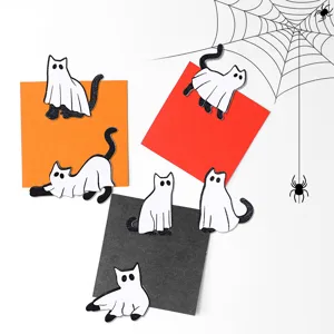 Close-up detail of cute Halloween ghost cat fridge magnets displayed on colorful paper cards.