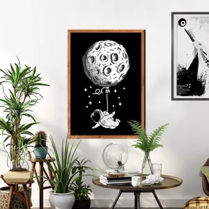 Detailed view of Scandinavian wooden frame wall art featuring astronaut and moon illustration.