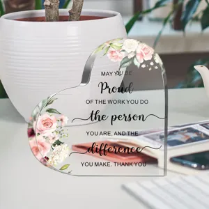 Close-up detail van hartvormig acryl plaquette met bloemenprint en inspirerende quote.