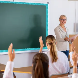 Scena in aula con bordo magnetico a pois blu sulla lavagna per decorazione scolastica.