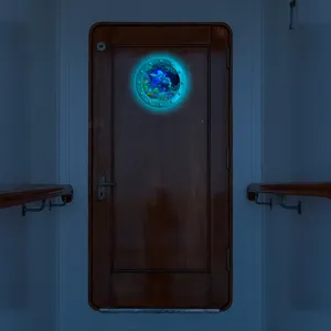 Detailed view of the luminous porthole wall sticker showing glowing underwater marine animals.