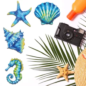 Detail shot of metal ocean wall hanging decor featuring blue seashell and starfish design.