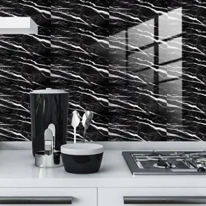 Détail d'adhésif carrelage marbre noir cuisine, film cristal imperméable décoration.