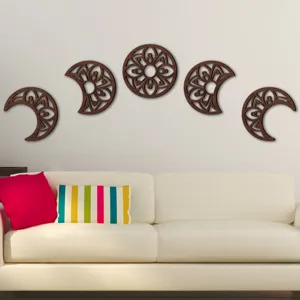 Detailed scene of carved wooden moon phase wall art hanging above a cozy living room sofa.