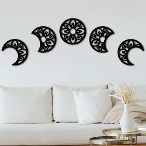 Wood moon phase wall hanging detail showing intricate hollow mandala carving design on white wall.
