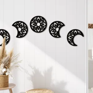 Detailed view of black wooden moon phase wall hanging with intricate hollow mandala patterns.