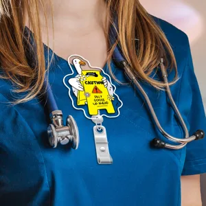 Cute silly goose badge reel detail shot, funny caution sign design with metal clip.