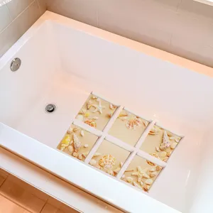 Close-up detail of anti-slip bathtub stickers featuring beach seashell patterns inside tub.