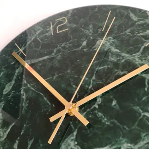 Close up of dark green marble wall clock with luxury gold hands and sleek modern design.