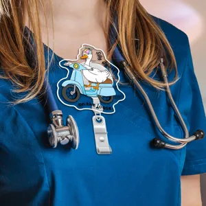Close-up detail of cute cartoon silly goose badge reel worn on medical scrubs uniform.