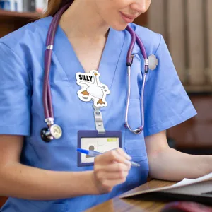 Detail shot of cute silly goose badge reel worn by nurse in scrubs, perfect for work daily use.