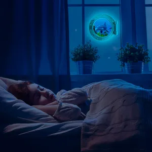 Detailed scene of glowing porthole wall sticker featuring ocean dolphin in cozy room at night.