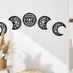 Detail view of black wooden moon phase wall hanging decor in cozy home interior setting.