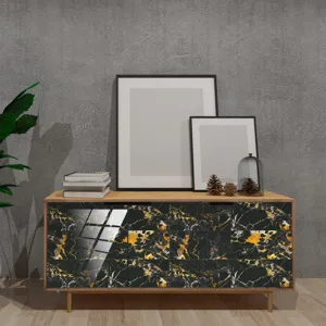 Vue détaillée d'un autocollant décoratif à motif de marbre noir et or appliqué sur un meuble.