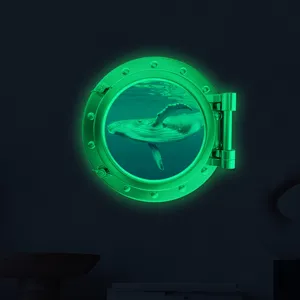 Luminous porthole wall sticker with underwater whale design glowing in dark room detail.