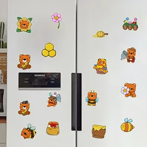 Vista dettagliata di simpatici adesivi magnetici con api e orsi cartoon sul frigorifero.