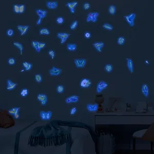 Gros plan d'autocollants muraux lumineux en forme de colibri et papillon dans une pièce.