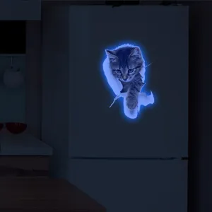 Detailed view of the luminous 3D cat wall sticker glowing in blue inside a dark room.