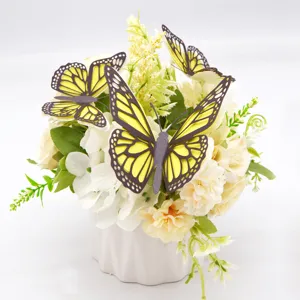 Gedetailleerd overzicht van 3D uitgeholde papieren vlinderdecoraties op bloemstuk.