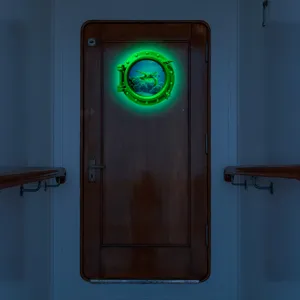 Close-up view of the luminous sea turtle porthole wall sticker glowing bright green in the dark.