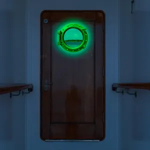 Detailed view of the luminous porthole wall sticker showing glowing green frame and ocean view.