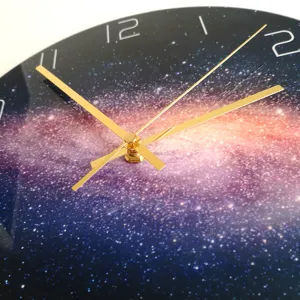 Vista detallada del reloj de pared galaxia con manecillas doradas y esfera de acrílico.