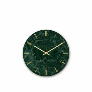Dettaglio dell'orologio da parete in marmo verde con lancette dorate e quadrante minimalista.