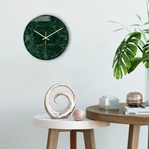 Green marble wall clock detail shot with golden hands and numbers in modern living room decor.