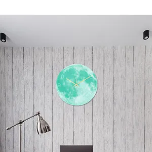Dettaglio dell'orologio da parete luna luminosa con superficie in acrilico e lancette dorate.