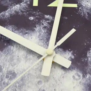 Luminous moon pattern wall clock detail close up view showing white clock hands and glowing number.