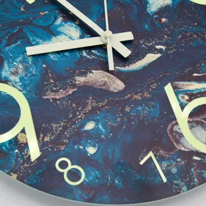 Luminous wall clock detail shot with blue marble fluid art pattern and glowing numbers.