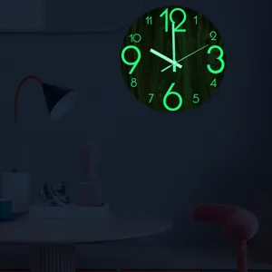 Close-up detail of a luminous wooden wall clock glowing green in a dark bedroom setting.