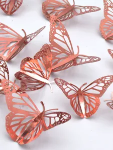 Close-up view of rose gold metallic 3D hollow butterfly wall stickers showing delicate cutouts.