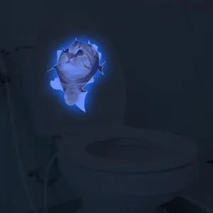 Detail view of the 3D luminous cat toilet sticker showing glowing blue effect in dark room.