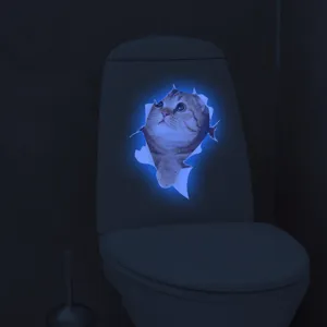 Glow in the dark 3D cat wall sticker showing luminous effect on toilet tank in dark room.