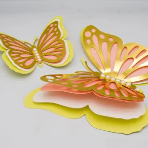 Detail shot of 3D layered hollow butterfly wall stickers with pearl accents, gold and pink.