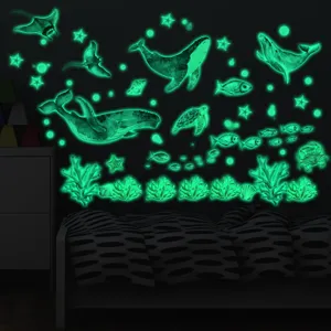 Detailed view of glowing ocean animal wall stickers in dark room, featuring whales and corals.