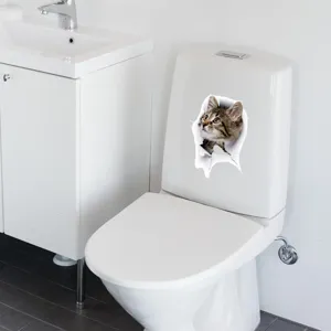 Detailed view of a realistic 3D cat wall sticker applied on a white toilet tank.