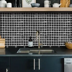 Primo piano di adesivo per piastrelle a mosaico bianco e nero per paraschizzi da cucina.