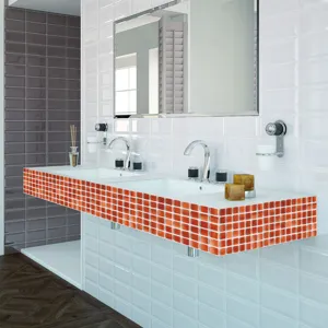 Vista dettagliata di adesivi per piastrelle a mosaico arancione su un piano lavabo da bagno.