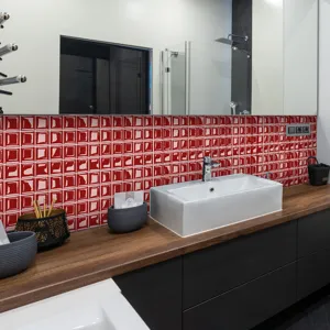 Detailed view of 3D red mosaic tile stickers applied on a modern bathroom wall surface.