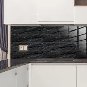 Détail de crédence de cuisine avec autocollant de carrelage effet marbre noir et brillant.