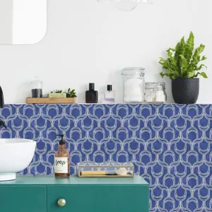 Detailed view of the blue geometric self-adhesive tile sticker applied on the bathroom wall.