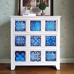 Vista detallada de adhesivos de azulejos vintage azules y plateados en una superficie blanca.