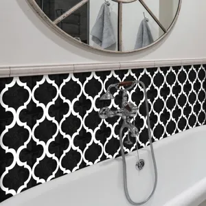 Bathroom wall sticker detail featuring black and white Moroccan quatrefoil tile pattern in interior.