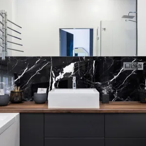 Vista de detalle cercana de la pegatina de azulejos con textura de mármol negro en baño moderno.