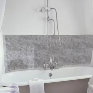Vista detallada del adhesivo de pared con textura de mármol gris en un baño moderno.