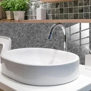 Close-up detail of dark grey marble texture wall tile sticker in modern bathroom decor scene.